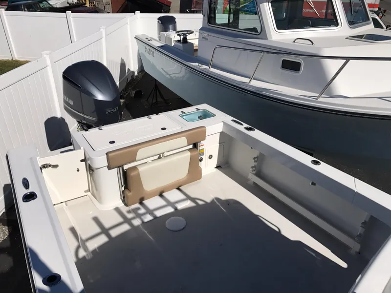 Slide: The Image of 2019 Parker 2320 SL Sport Cabin boat with Yamaha outboard motor, docked near white fence. - 8