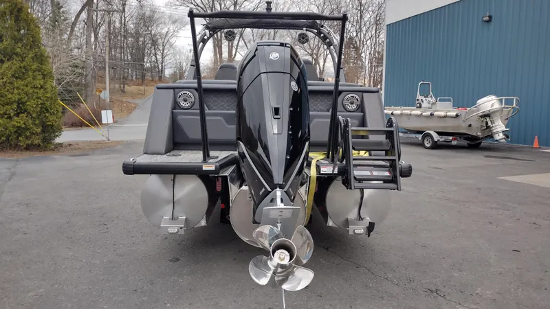 Slide: The Image of 2025 Viaggio Diamante boat with dual propellers, parked outdoors near a blue building. - 7