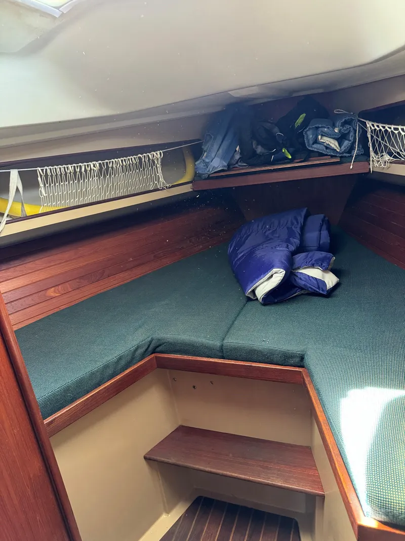 Slide: The Image of 1984 C&C 35 MK III sailboat cabin with green cushions and storage shelves. - 15
