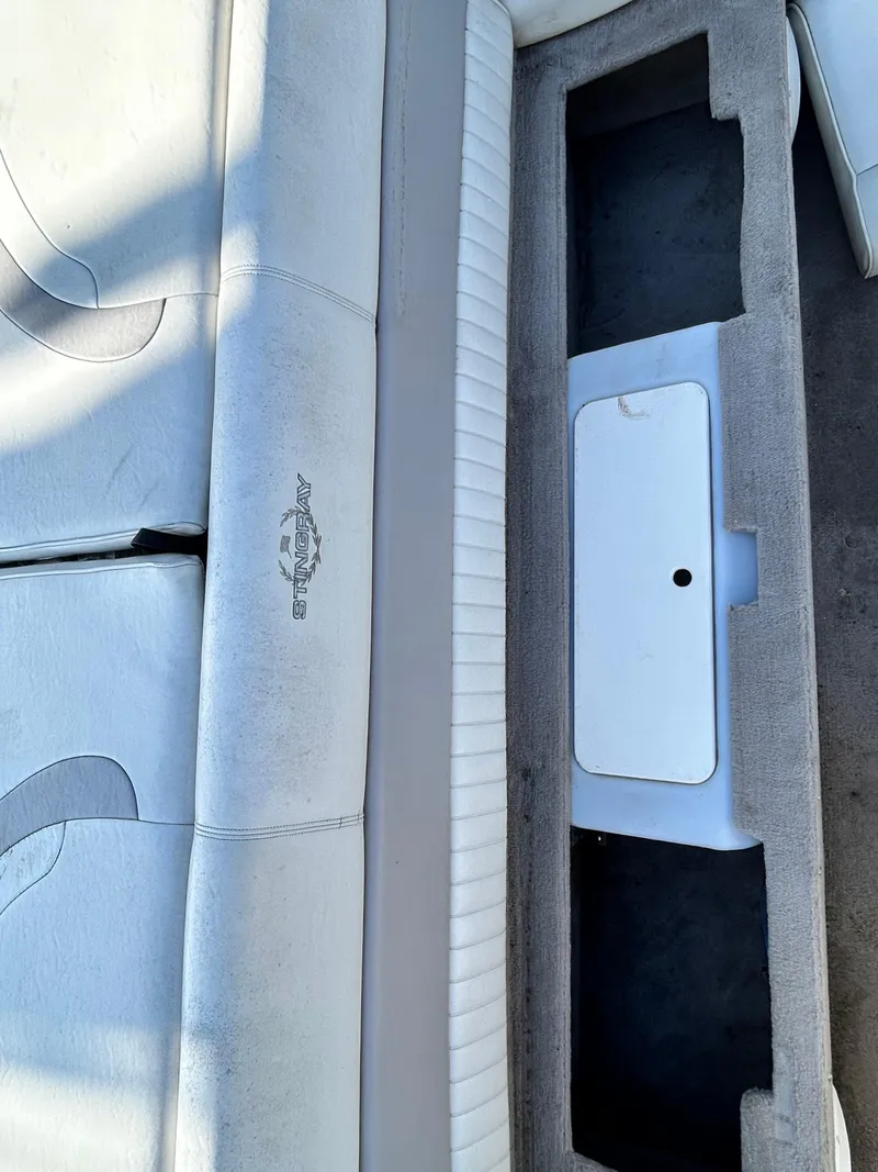 Slide: The Image of 2005 Stingray 195 FX boat interior with white seating and storage compartment. - 10