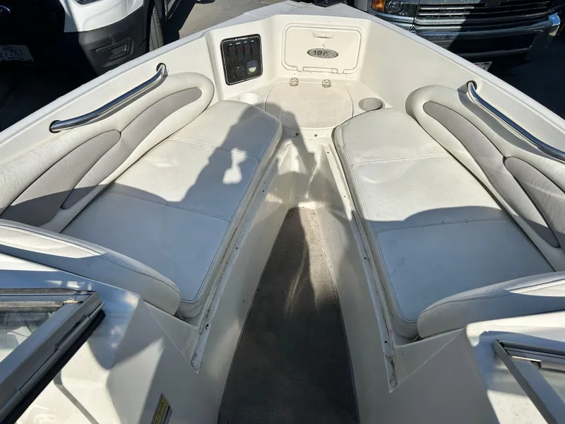 Slide: The Image of 2005 Stingray 195 FX boat interior with white cushioned seating and storage compartments. - 20