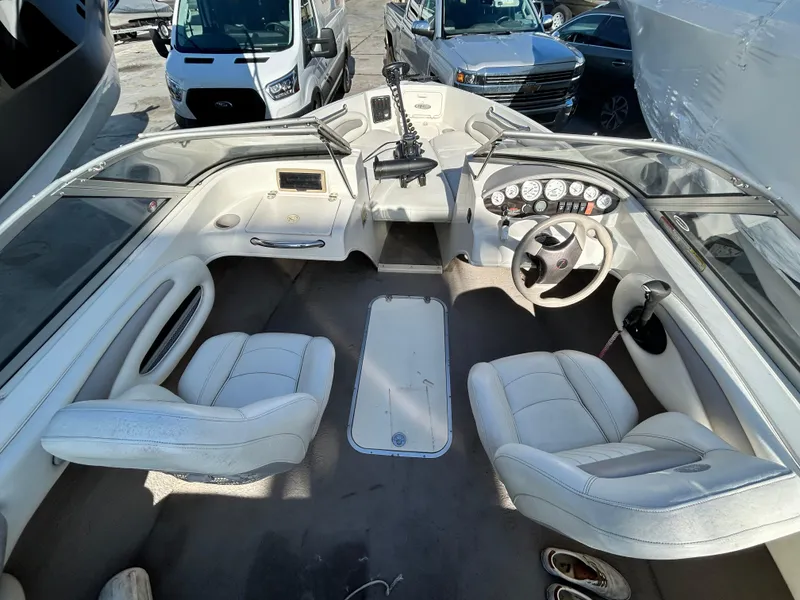 Slide: The Image of 2005 Stingray 195 FX boat interior with white seating and dashboard controls. - 3