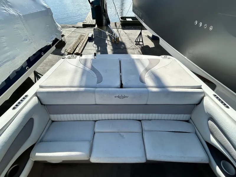 Slide: The Image of 2005 Stingray 195 FX boat interior with white cushioned seating, dockside view. - 6
