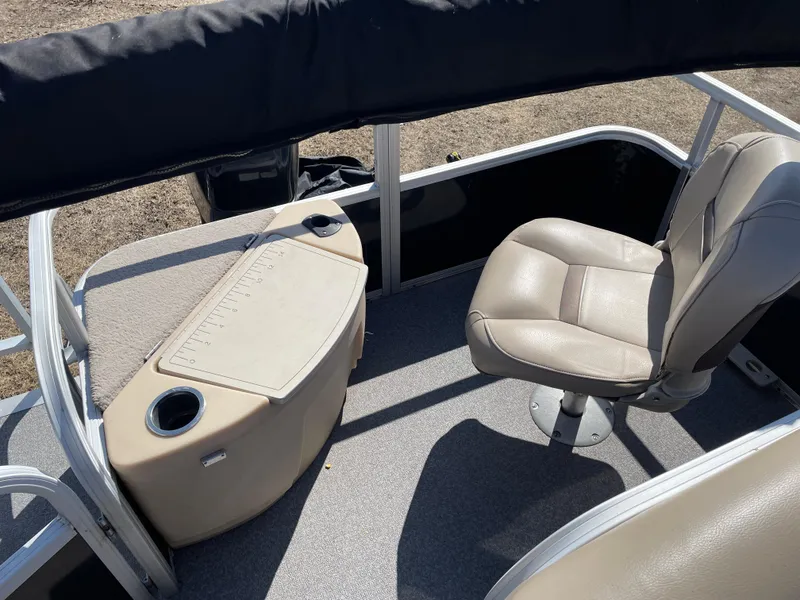 Slide: The Image of 2017 Sun Tracker BB18 boat interior with beige seating and storage compartment. - 10
