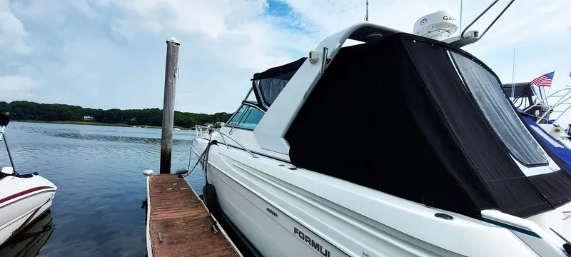Slide: The Image of 1998 Formula 41 PC yacht docked by a serene lake under a partly cloudy sky. - 33
