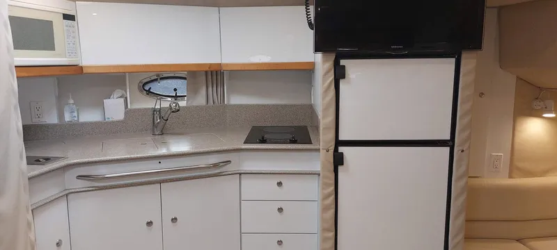 Slide: The Image of 1998 Formula 41 PC yacht interior kitchen with white cabinetry and appliances. - 6