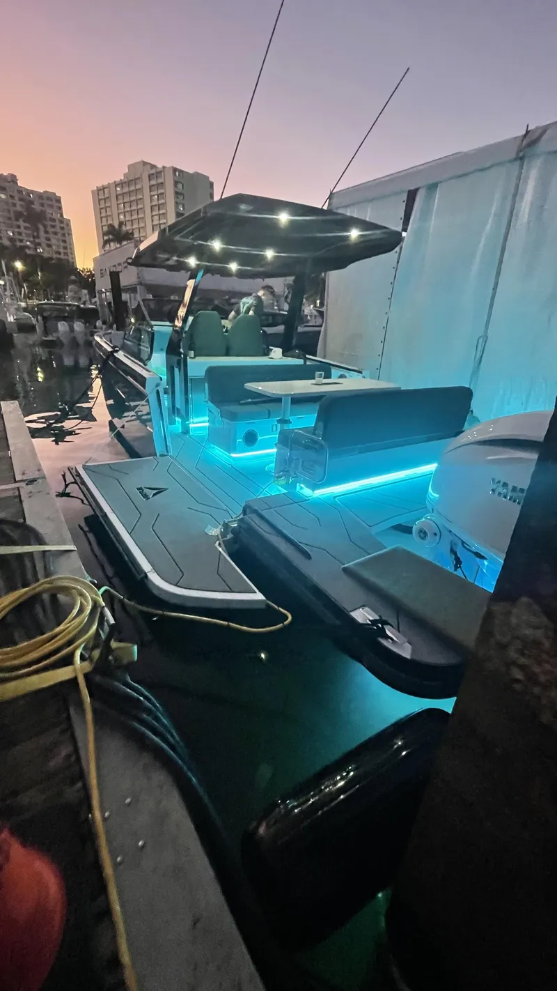 Slide: The Image of 2025 Virtue V10Top boat with blue LED lights docked at sunset. - 0