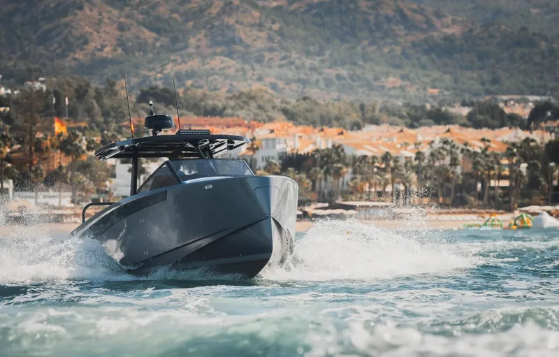 Slide: The Image of 2025 Virtue V10Top boat cruising on water with scenic coastal backdrop. - 1