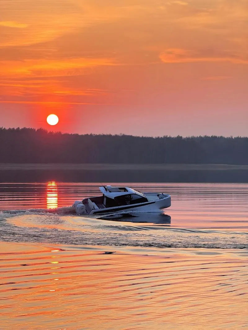 Slide: The Image of A Virtue V10Top boat cruising on a serene lake at sunset, 2025 model. - 12