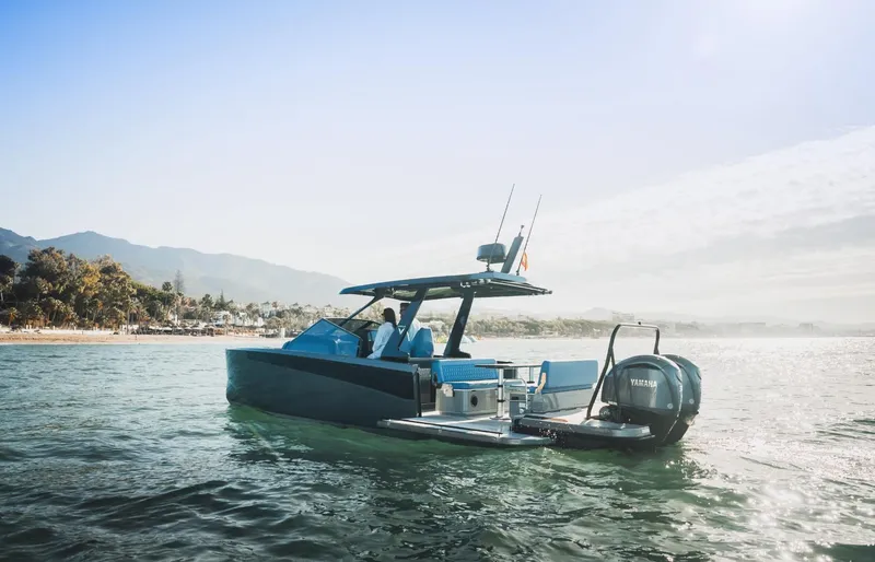 Slide: The Image of Modern 2025 Virtue V10Top boat cruising near a scenic coastline. - 2