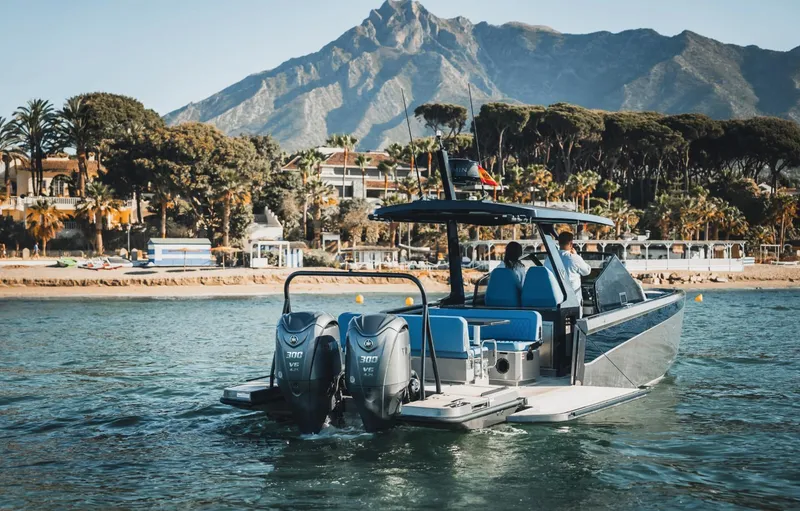 Slide: The Image of 2025 Virtue V10Top boat cruising near scenic coastline with mountains in the background. - 5