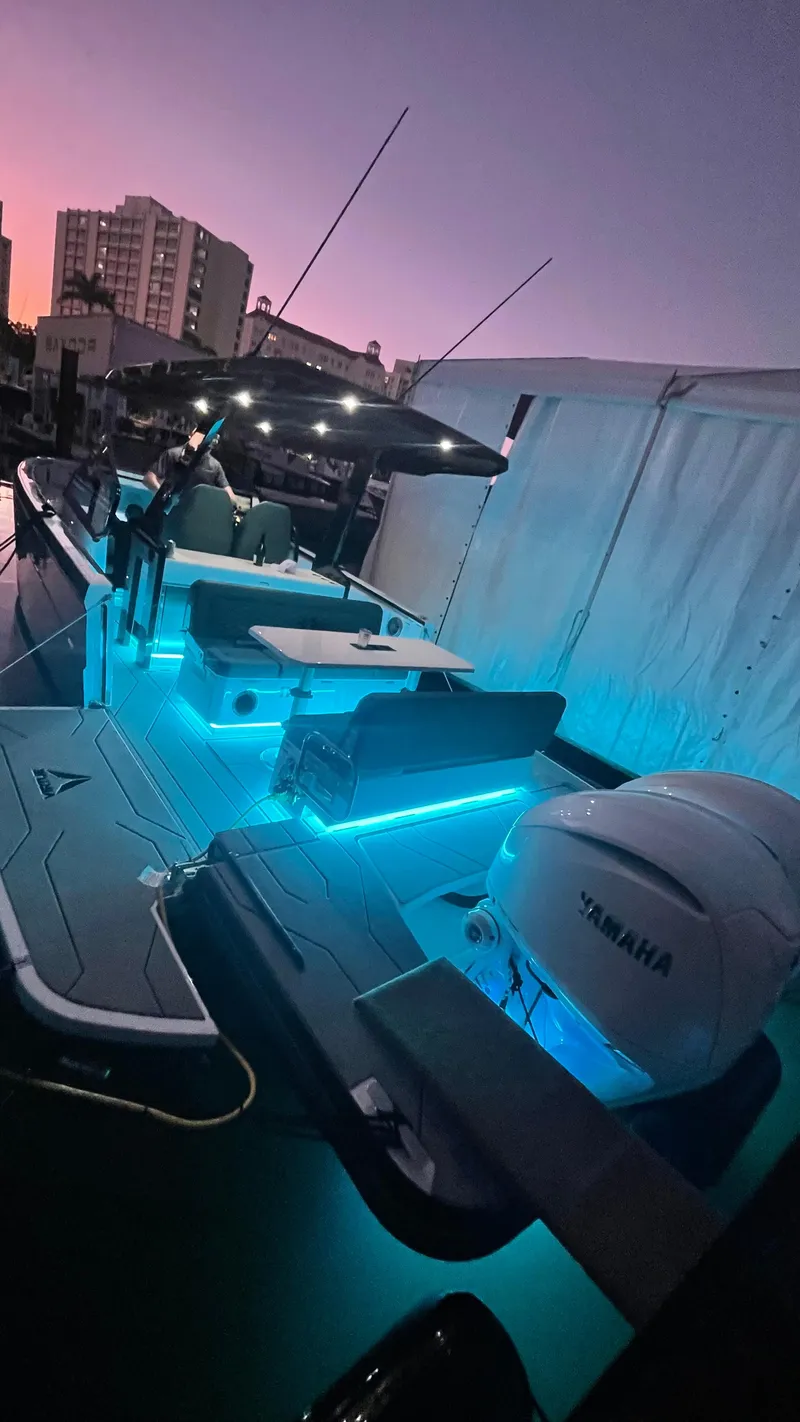 Slide: The Image of Virtue V10Top 2025 boat with blue LED lights at sunset, docked near cityscape. - 8