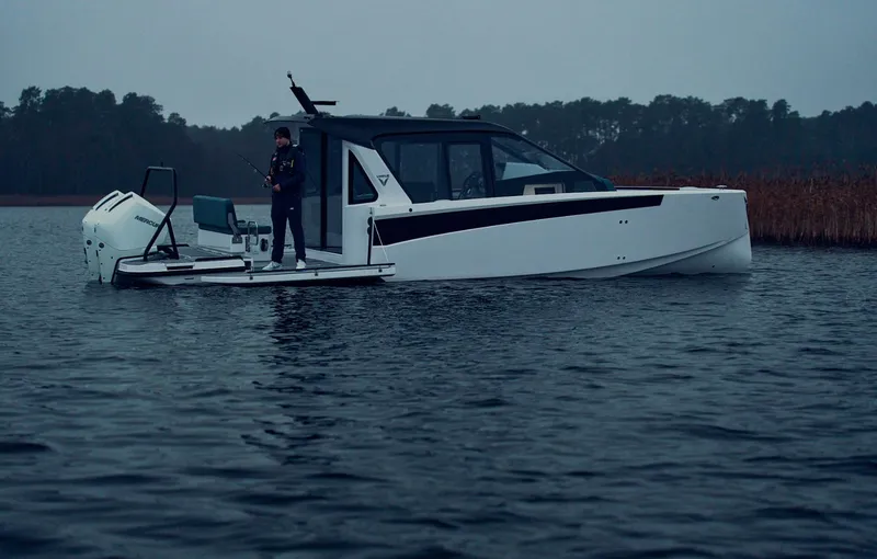 Slide: The Image of 2025 Virtue V10Top boat on calm water with person standing on deck. - 9