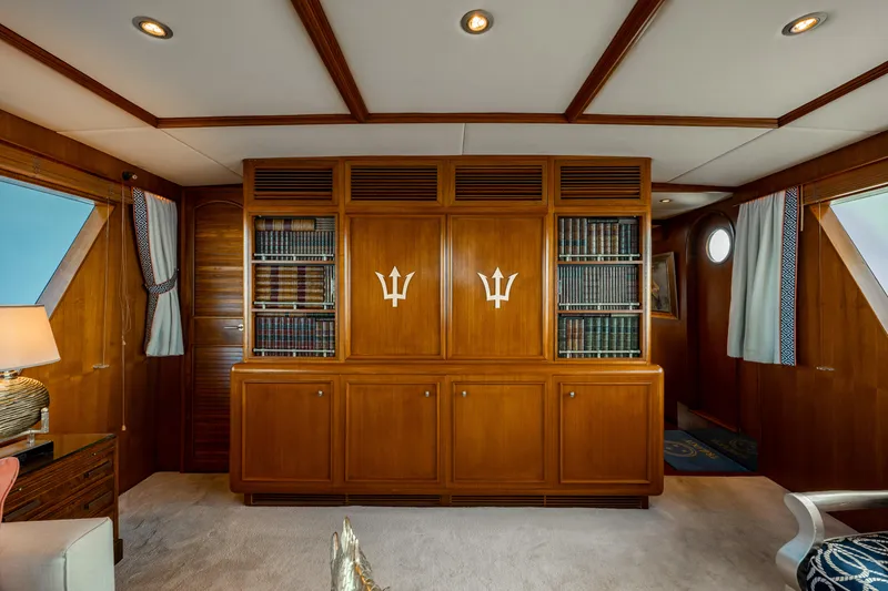 Slide: The Image of Luxurious wood-paneled interior of a 1985 Cheoy Lee 90 Motor Yacht with built-in shelving. - 12