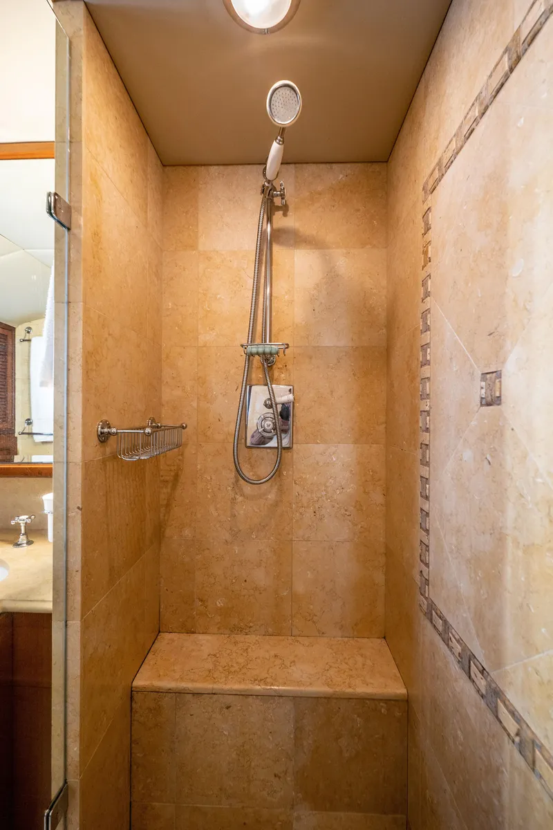 Slide: The Image of Shower area in 1985 Cheoy Lee 90 Motor Yacht with beige tiles and built-in bench. - 24