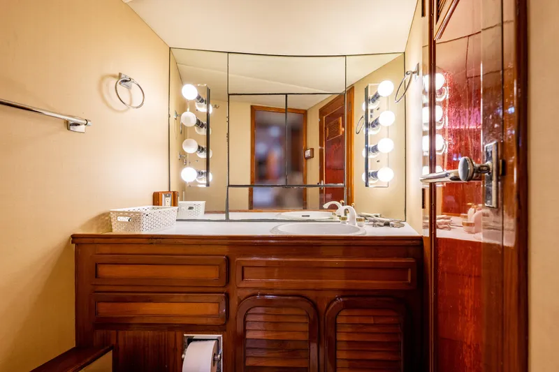 Slide: The Image of Luxurious bathroom in a 1985 Cheoy Lee 90 Motor Yacht with mirrored vanity and warm lighting. - 30