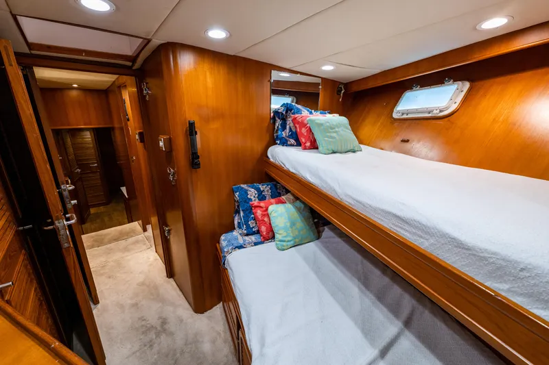 Slide: The Image of 1985 Cheoy Lee 90 Motor Yacht interior with cozy bunk beds and wooden paneling. - 34
