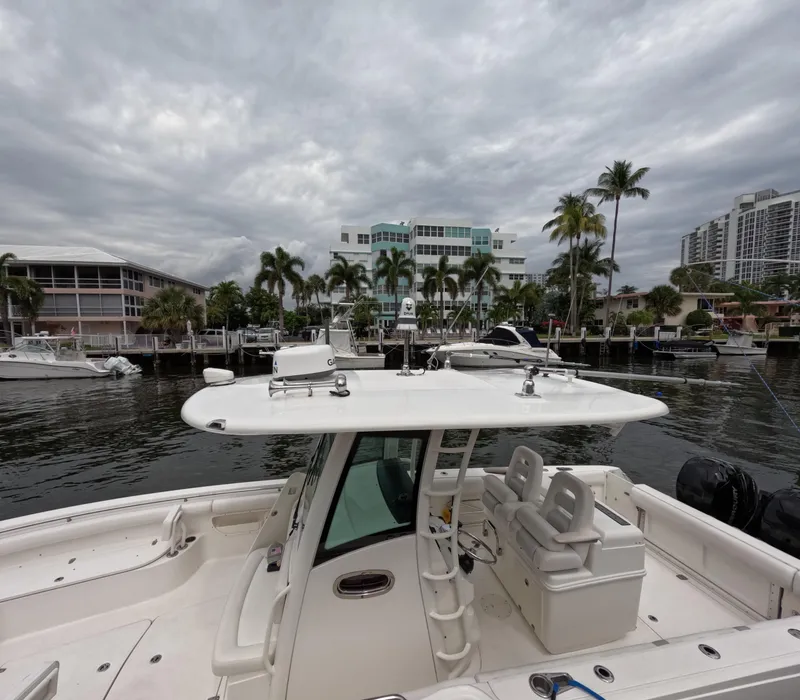 Slide: The Image of 2013 Boston Whaler 320 Outrage boat docked in a marina with cloudy skies. - 16