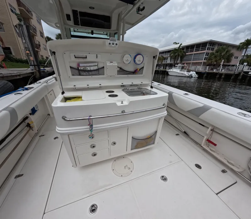 Slide: The Image of 2013 Boston Whaler 320 Outrage boat interior with open storage and fishing equipment. - 21