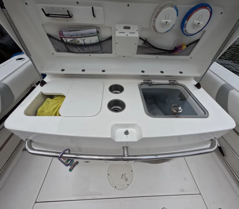 Slide: The Image of 2013 Boston Whaler 320 Outrage boat interior with sink and storage compartments. - 22
