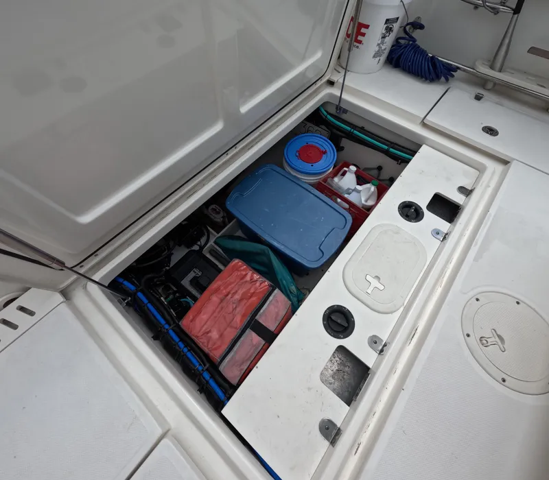 Slide: The Image of Storage compartment of a 2013 Boston Whaler 320 Outrage, containing various boating supplies. - 23