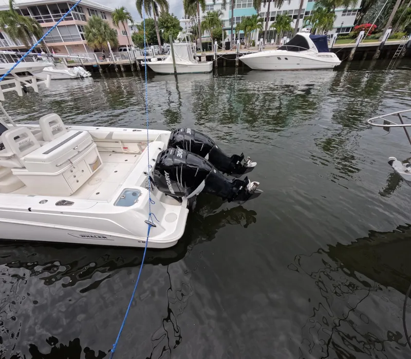 Slide: The Image of 2013 Boston Whaler 320 Outrage docked with dual outboard motors, marina background. - 28
