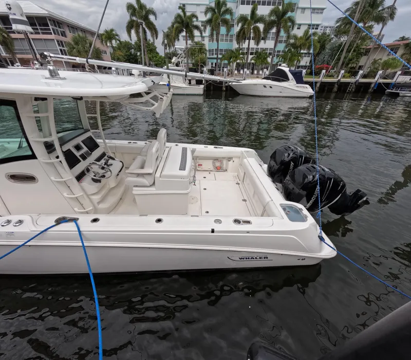 Slide: The Image of 2013 Boston Whaler 320 Outrage boat docked in marina with palm trees. - 29