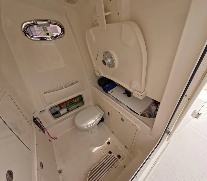 Slide: The Image of Interior of 2013 Boston Whaler 320 Outrage boat, featuring a compact marine toilet. - 3