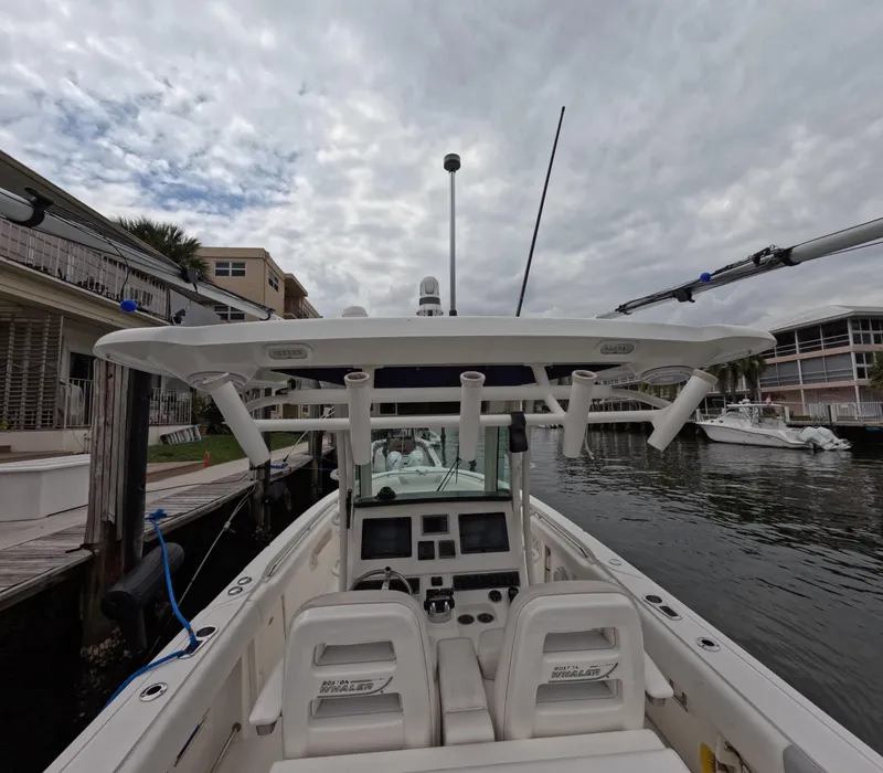 Slide: The Image of 2013 Boston Whaler 320 Outrage boat docked, featuring dual helm seats and advanced navigation equipment. - 33