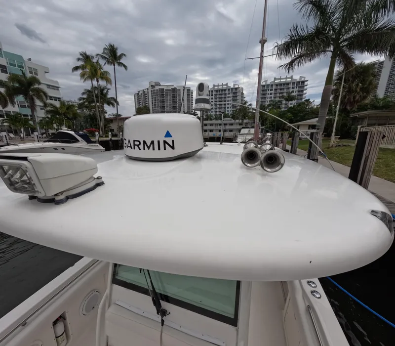 Slide: The Image of Boston Whaler 320 Outrage 2013 boat with Garmin radar, docked near palm trees and buildings. - 37