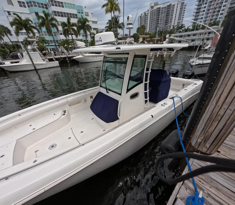 Slide: The Image of 2013 Boston Whaler 320 Outrage docked at marina, surrounded by palm trees and buildings. - 45