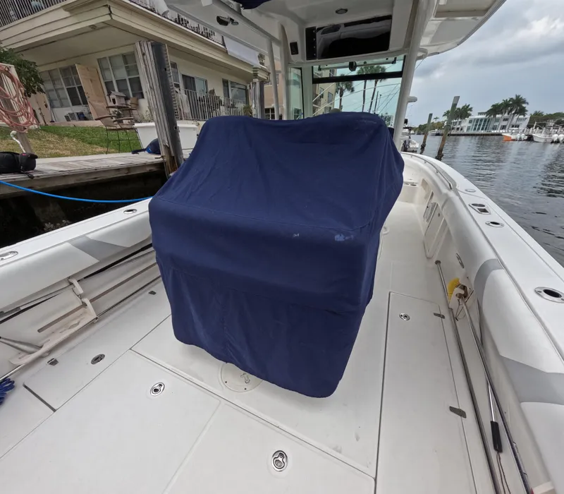 Slide: The Image of 2013 Boston Whaler 320 Outrage boat interior with covered seating, docked by waterfront homes. - 46