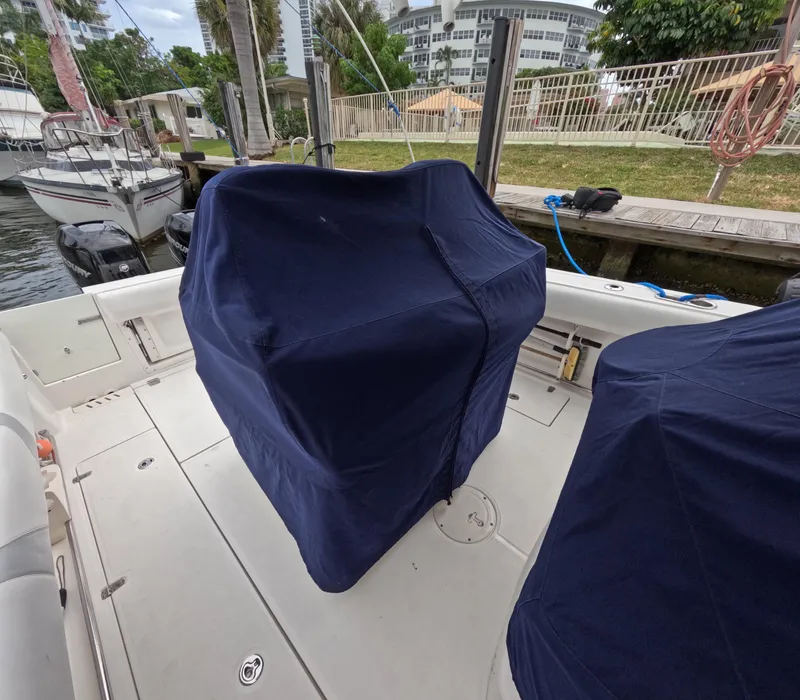 Slide: The Image of 2013 Boston Whaler 320 Outrage boat with covered seats docked near a marina. - 47