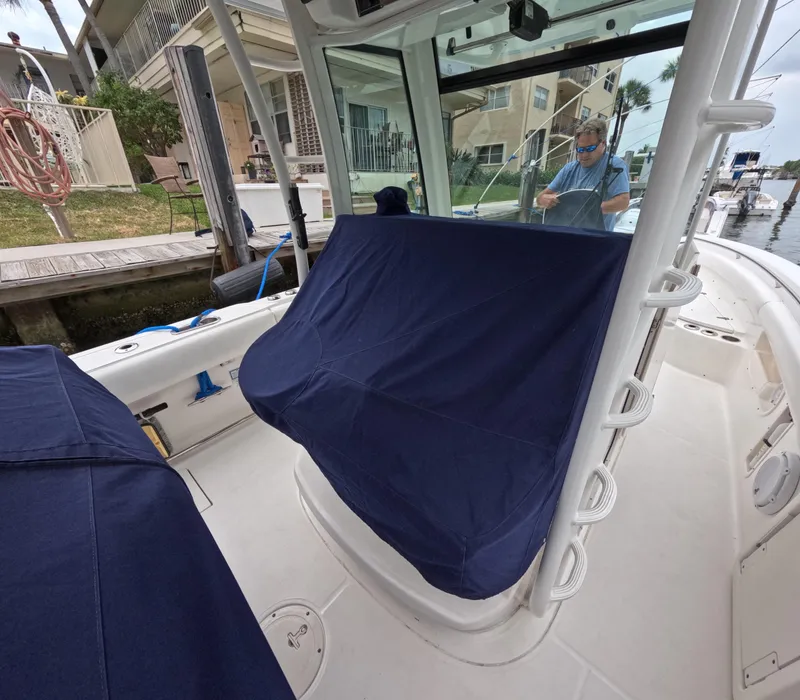 Slide: The Image of 2013 Boston Whaler 320 Outrage interior with covered seating, docked near waterfront homes. - 48