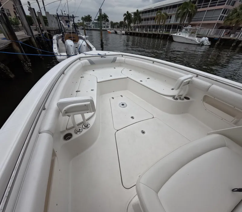 Slide: The Image of 2013 Boston Whaler 320 Outrage boat interior, docked near waterfront buildings and palm trees. - 5