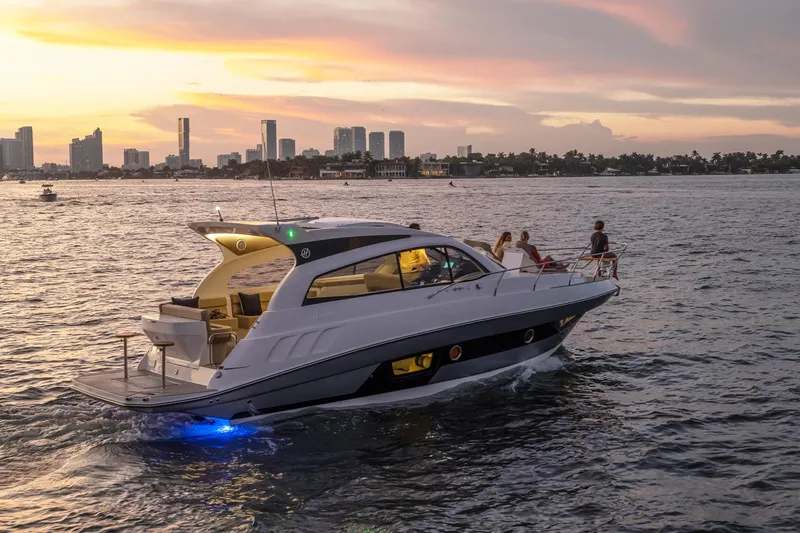 Slide: The Image of Luxury Hanover 375 yacht cruising at sunset near city skyline, 2025 model. - 30
