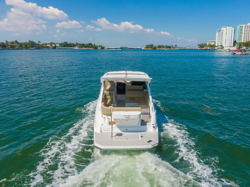 Slide: The Image of 2025 Hanover 375 boat cruising on clear blue water near coastal buildings. - 6