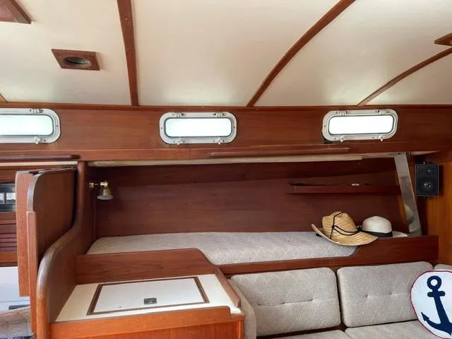 Slide: The Image of 1984 Tartan T-33 yacht interior with wooden finish, cozy seating, and nautical decor. - 17