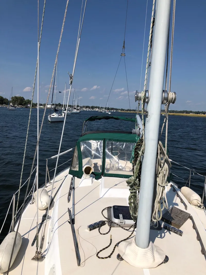 Slide: The Image of 1984 Tartan T-33 sailboat on calm water, clear sky, and distant boats. - 2