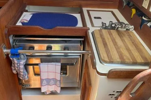Slide: The Image of 1984 Tartan T-33 yacht kitchen with stove, cutting board, and wooden cabinetry. - 22