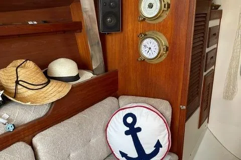 Slide: The Image of Cozy Tartan T-33 yacht interior with nautical decor, featuring anchor pillow and straw hats. - 28