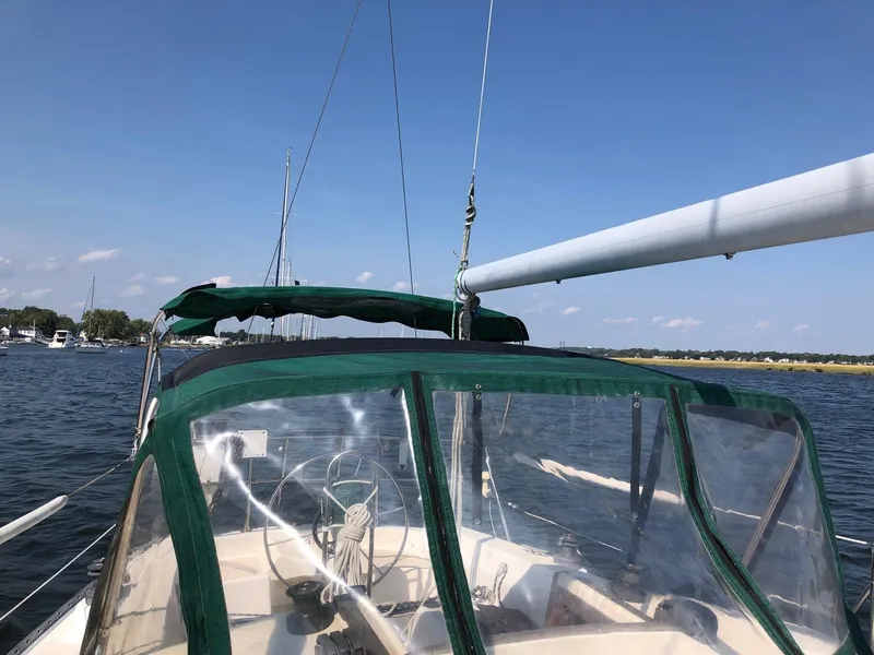 Slide: The Image of Sailboat Tartan T-33, 1984 model, with green canopy on calm water under clear blue sky. - 3