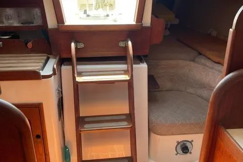 Slide: The Image of 1984 Tartan T-33 yacht interior with wooden ladder and cozy seating area. - 30