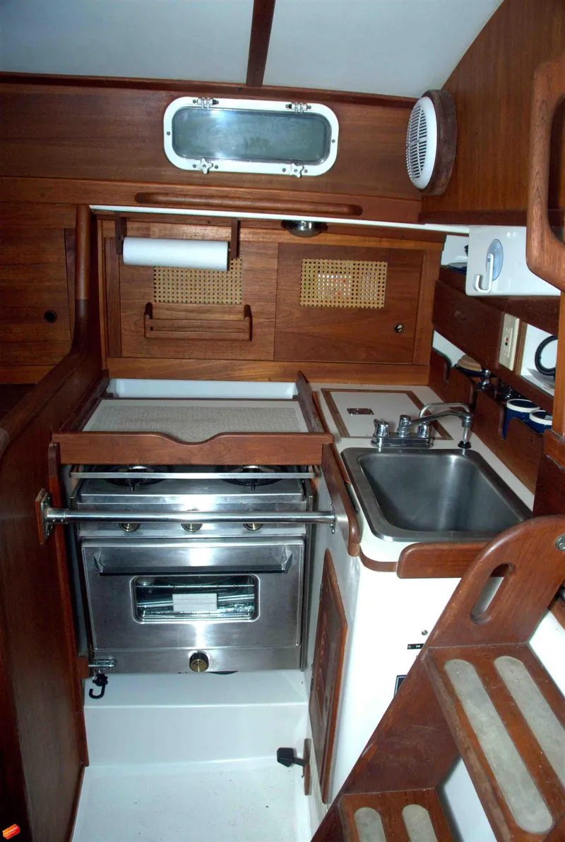 Slide: The Image of 1984 Tartan T-33 yacht kitchen with wood cabinetry and stainless steel appliances. - 5
