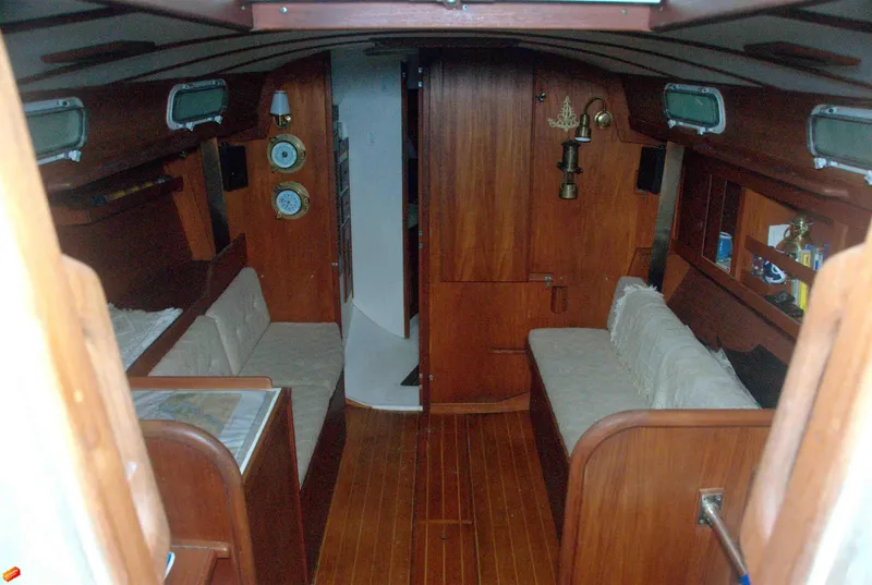 Slide: The Image of 1984 Tartan T-33 yacht interior with wooden finish and cozy seating area. - 7
