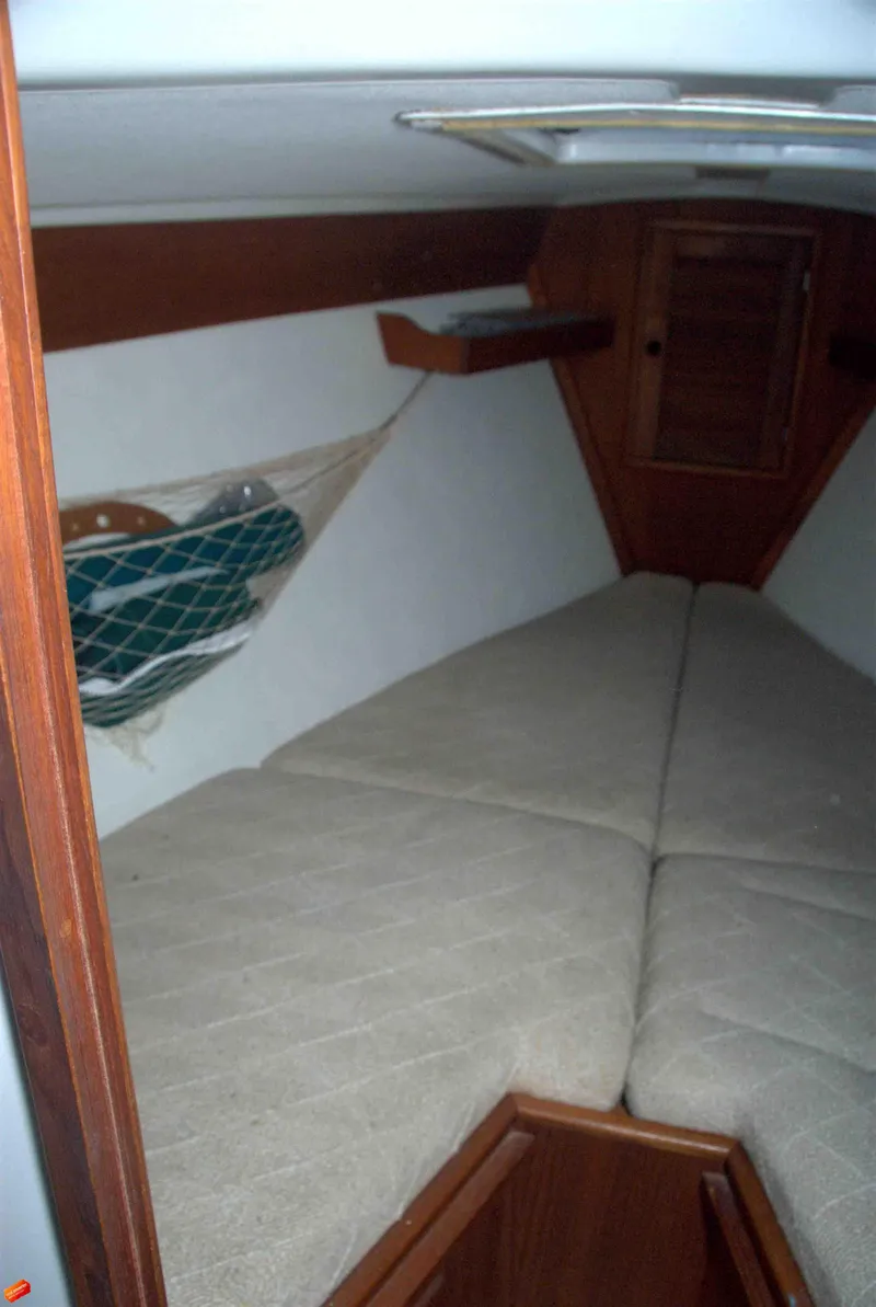 Slide: The Image of 1984 Tartan T-33 sailboat interior cabin with V-berth and wooden accents. - 8