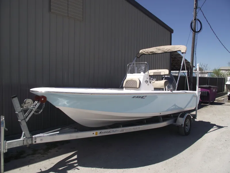 Slide: The Image of 2022 Tidewater 1910 Bay Max boat on trailer, parked outdoors near a building. - 1