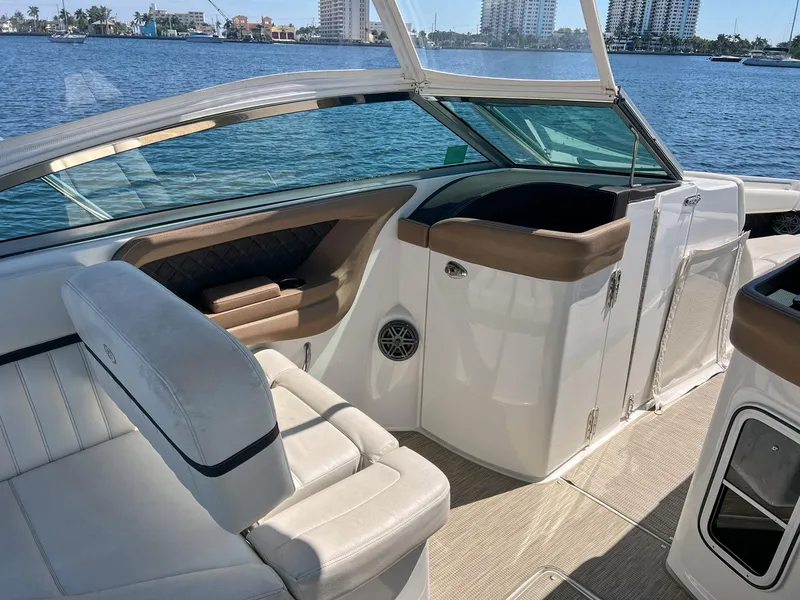Slide: The Image of 2016 Cobalt 336 boat interior with white seating, brown accents, and waterfront view. - 11