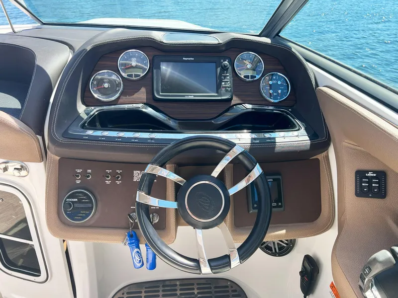 Slide: The Image of Steering wheel and dashboard of a 2016 Cobalt 336 boat, featuring gauges and controls. - 15