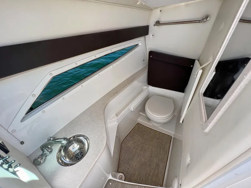 Slide: The Image of 2016 Cobalt 336 boat interior bathroom with sink, toilet, and window view. - 7